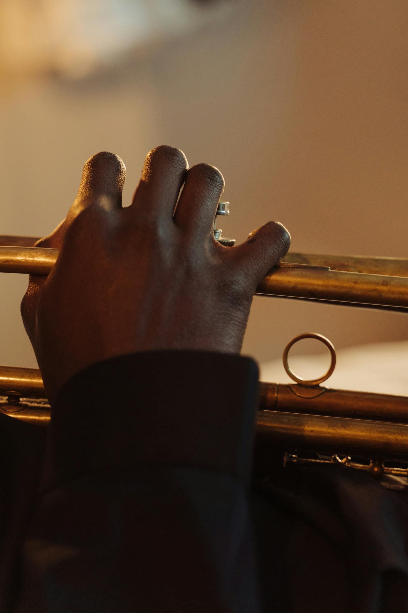 A close-up view of a musician playing a trumpet with blurred background focus.